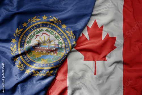 big waving realistic national colorful flag of new hampshire state and national flag of canada . photo
