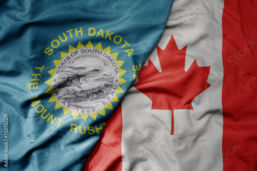big waving realistic national colorful flag of south dakota state and national flag of canada . photo