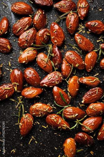 Roasted rosemary almonds  on a black background, close up view