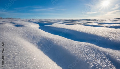 beautiful winter background with snowy ground natural snow texture wind sculpted patterns on snow surface wide panoramic texture for background and design