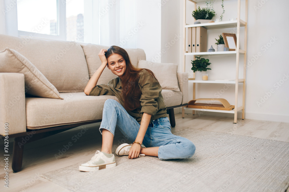 Cozy Home Bliss: A Happy Woman Relaxing on a Modern Sofa in her Comfortable Apartment.