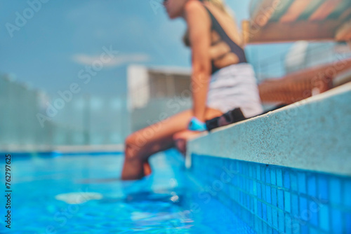 Unrecognizable woman legs during summer day in a swimming pool.