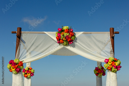 Outdoor wedding huppah fall colors blue sky photo