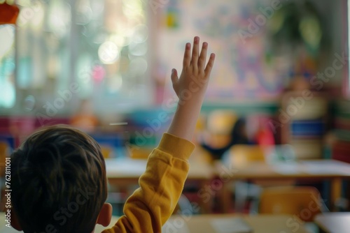 A boy in a yellow shirt raises his hand in a classroom