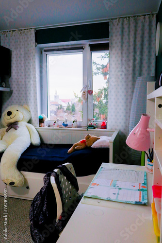 big white teddy bear coloured teenager room  with green walls and white bead in a bright day 