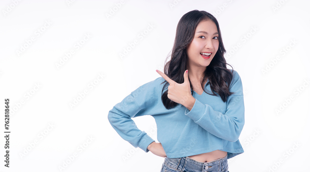 Cheerful excited asian woman use finger pointing to side with product or empty copy space standing over isolated white background. Model young girl laughing promotion. Advertisement presenting concept Cheerful excited asian woman use finger pointing to side with product or empty copy space standing over isolated white background. Model young girl laughing promotion. Advertisement presenting concept