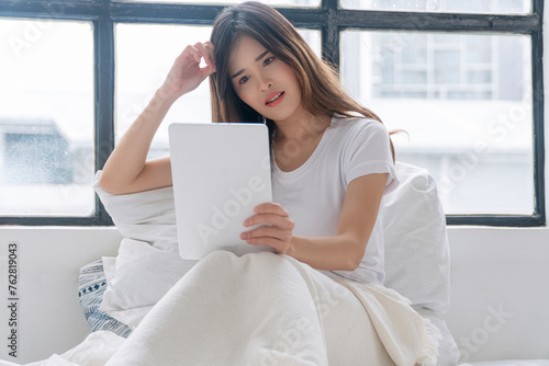 Thoughtful asian woman looking problem investment in tablet sitting on bed white pillow at apartment. Freelance young girl looking screen tablet information finance upset worried thinking. Technology. Free Download Thoughtful asian woman looking problem investment in tablet sitting on bed white pillow at apartment. Freelance young girl looking screen tablet information finance upset worried thinking. Technology. - GFXLoad