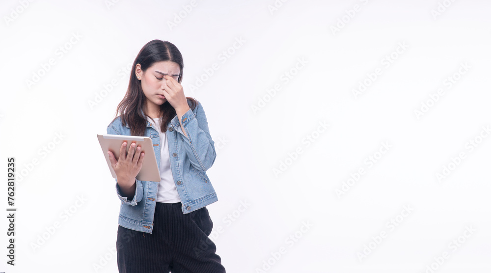 Tired woman wear jean jacket holding hand eye strain with digital tablet trouble reading overworked media online over isolated white background. Unhappy young girl touching eye ache vision problem. Tired woman wear jean jacket holding hand eye strain with digital tablet trouble reading overworked media online over isolated white background. Unhappy young girl touching eye ache vision problem.