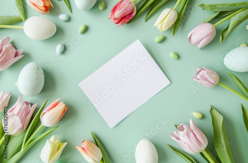 top down view of Easter eggs and spring tulips with a blank white label. Easter invite poster