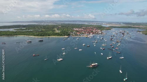 Orbital drone footage of boats in Keramba Wayan Apel Strait on sunny day. Serangan, Denpasar, Bali. photo