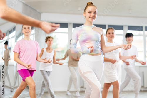Group of teenagers learn to dance hip-hop and other modern dances in a spacious dance studio