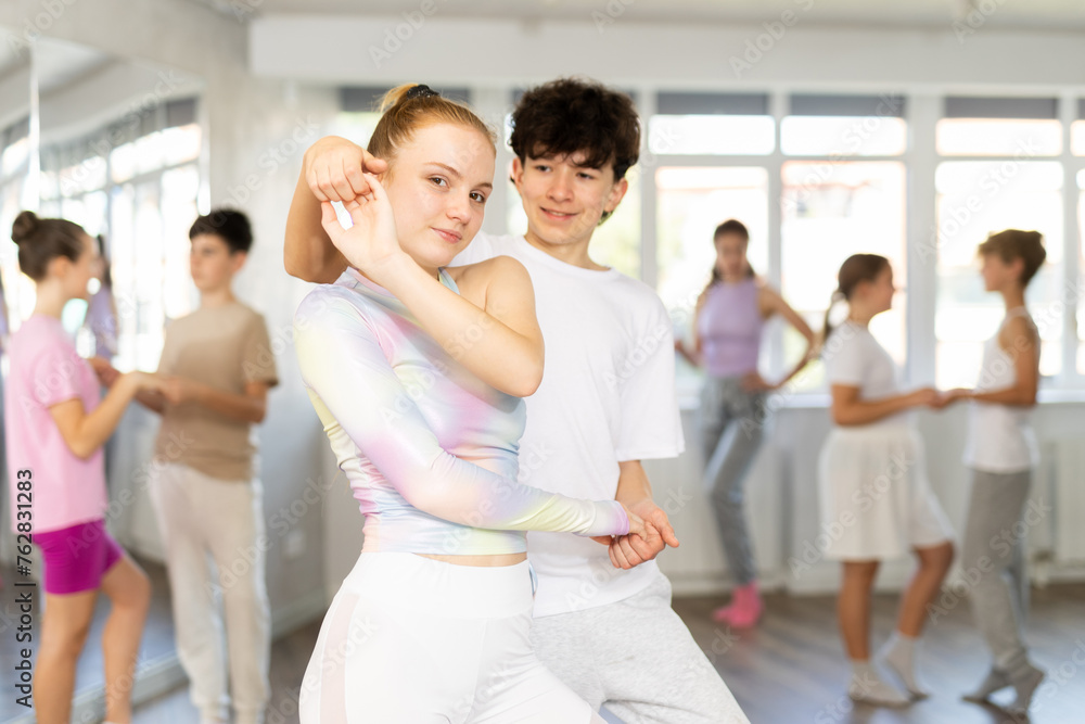Fototapeta premium Teenage boy and girl dancing ballroom waltz dance in studio