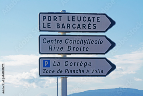 Panneaux de direction : Port-Leucate, centre conchylicole rive droite, parking La Corrège, zone de planche à vole, Aude, Languedoc, Occitanie, France ; Le Barcarès, Pyrénées orientales.