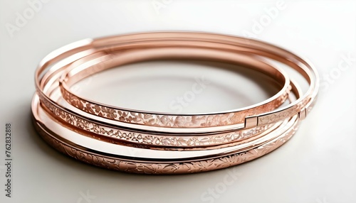 A Stack Of Slim Rose Gold Bangles Engraved With Fl Upscaled 10