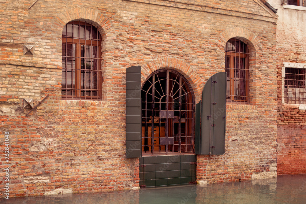 The metal gate above the canal in Venice is a gate made of black lattice. entrance to the house in Venice The metal gate above the canal in Venice is a gate made of black lattice. entrance to the house in Venice