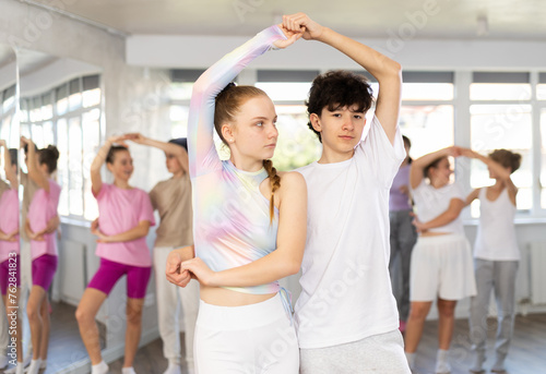 Couple teenagers boy and girl rehearsing pair waltz dance in studio © JackF