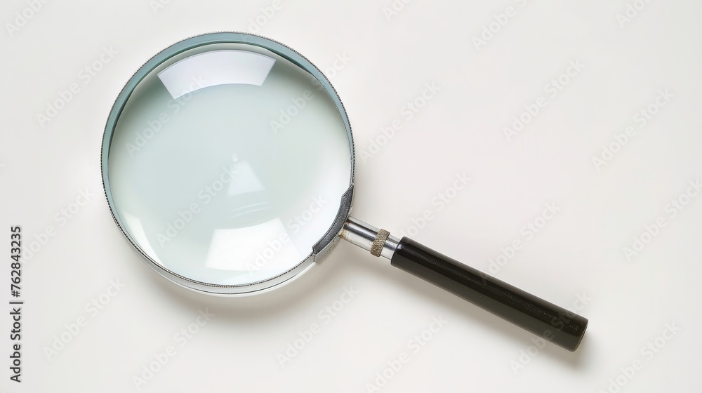 A magnifying glass presented in isolation against a white background, offering a clear view of its design and functionality A magnifying glass presented in isolation against a white background, offering a clear view of its design and functionality