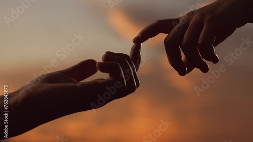 Hands touching each other. Finger Touching hands, silhouette of Hands in sky, couple feels love. Gentle touch with fingers of hands in sunset. Reunion of loved ones, family happiness. People together photo