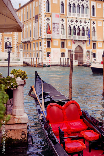view of the gondola with a red red seat on the background of the palace in Venice