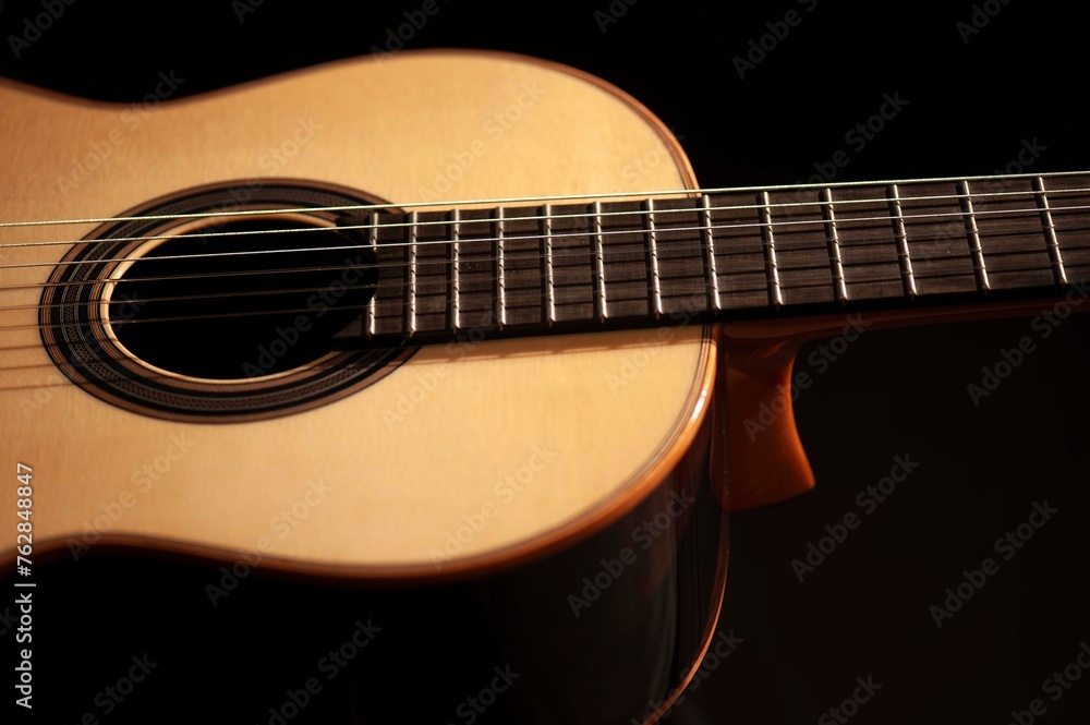 Classical Spanish flamenco guitar close up, dramatically lit isolated on black background with copy space. Classical Spanish flamenco guitar close up, dramatically lit isolated on black background with copy space.