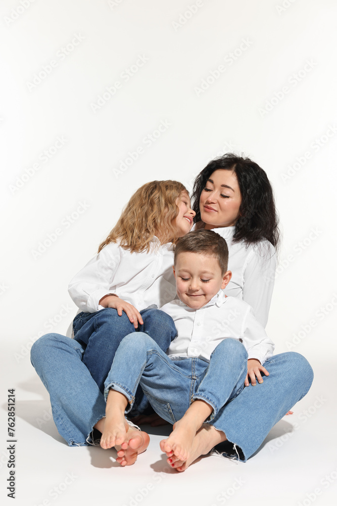 Little children with their mother sitting together on white background Little children with their mother sitting together on white background