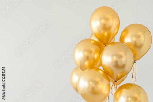 Bunch of shiny golden balloons on a light background, symbolizing celebration and festivity.