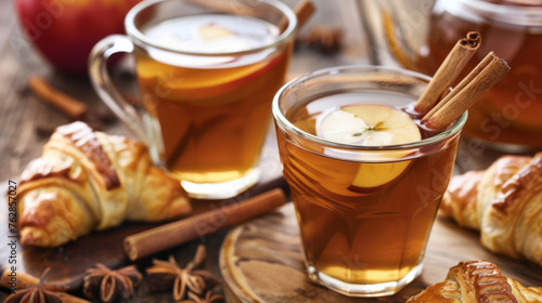 Hot apple cider is poured into mugs and garnished with cinnamon sticks enjoyed alongside warm apple turnovers.