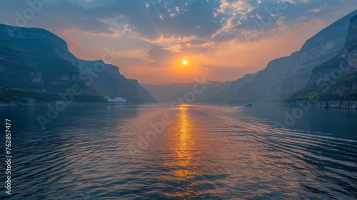 The sun is setting over a body of water, casting a warm glow on the surface