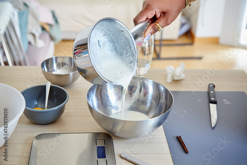 Black Hand Pouring Cream Mixture into a Bowl