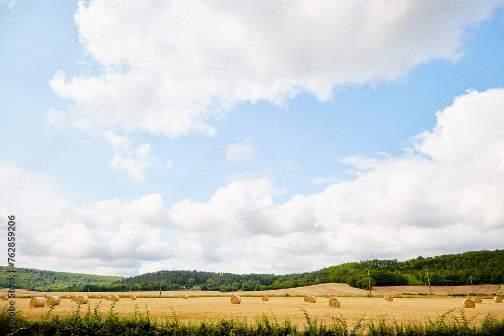 Dramatic Sky and Clouds with Rolls of Hay on the Landscape