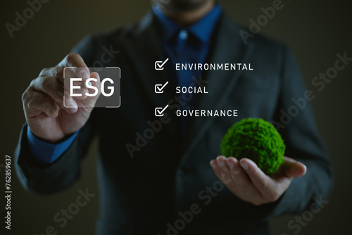 Businessman holding globe with ESG icon green earth concept for environment Society and Governance sustainable environmental concept of the world, green business natural environment. Save earth. © Looker_Studio