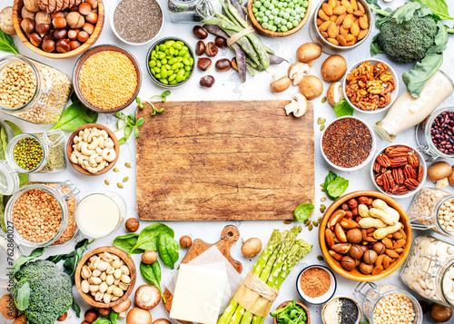 Vegan food background with copy space cutting board. Plant protein., vegetarian nutrition sources. Healthy eating, diet ingredients: legumes, beans, lentils, nuts, soy milk, tofu, cereals, seeds 