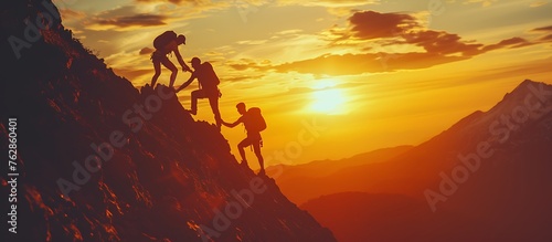 silhouette of a group of people helping each other to reach the top of a mountain in a sunset landscape