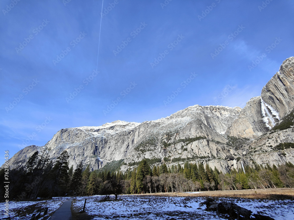 Fototapeta premium Winter's Patchwork at Yosemite: The Diverse Landscape of Snow, Meadow, and Majestic Peaks in the National Park of the United States