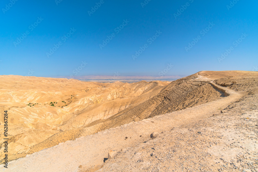 Hike to the dead sea horizon on clear blue sky day in the desert hot air