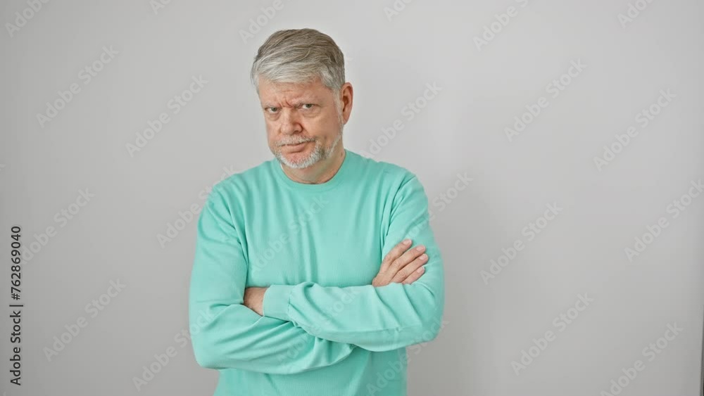 Skeptical grey-haired, middle-age man in casual attire, frowning with crossed arms. negative, disapproving look on his face. shot against an isolated white background. Skeptical grey-haired, middle-age man in casual attire, frowning with crossed arms. negative, disapproving look on his face. shot against an isolated white background.