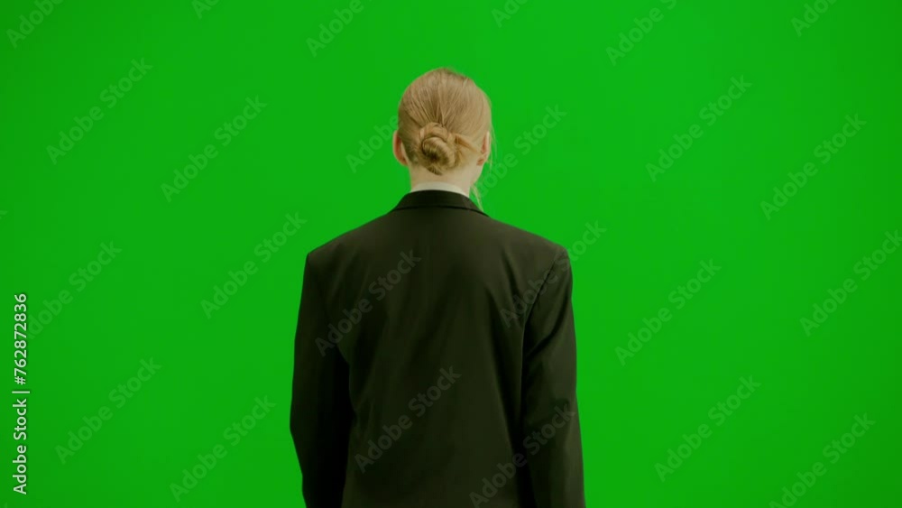 Portrait of female in suit on chroma key green screen. Blonde business woman in formal outfit walking checking hand watch and starts running. Back view. Portrait of female in suit on chroma key green screen. Blonde business woman in formal outfit walking checking hand watch and starts running. Back view.