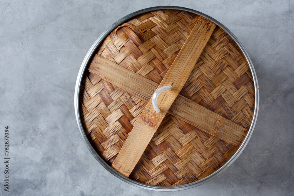 A top down view of the top portion of a bamboo steamer basket. A top down view of the top portion of a bamboo steamer basket.