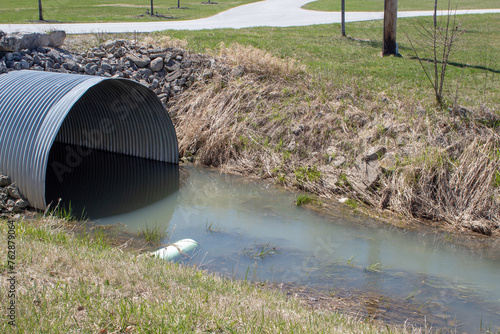 Canvas Print A water ditch with a riveted corrugated steel culvert.