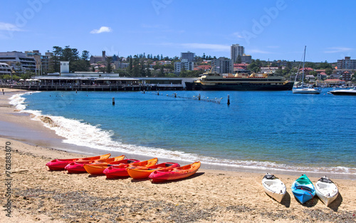 Kayaks on Manly cove beach with the ferry in the background