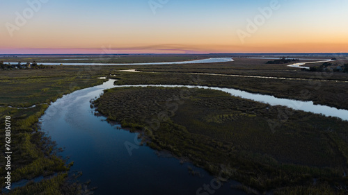 sunset over rivers running through marsh lands