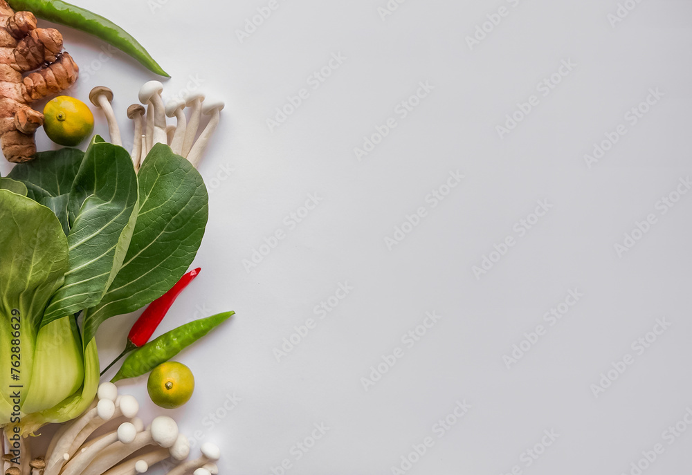 Assorted fresh vegetables including bok choy, mushrooms, chili peppers, and ginger on a white background with copy space for text, ideal for culinary themes or healthy eating concepts - obrazy, fototapety, plakaty 