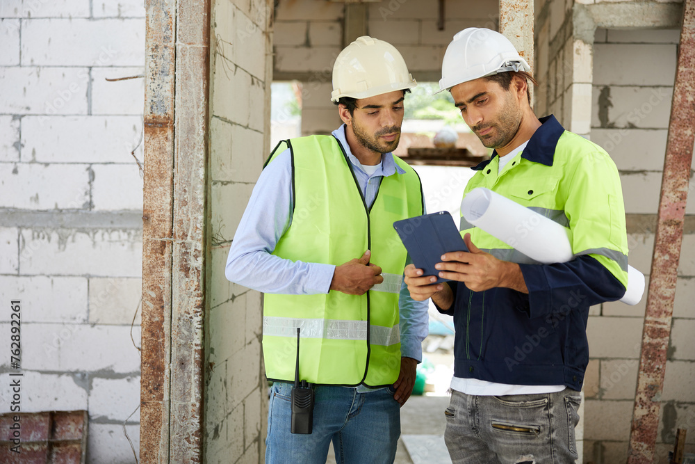 workers or architects meeting and working on tablet at construction site workers or architects meeting and working on tablet at construction site