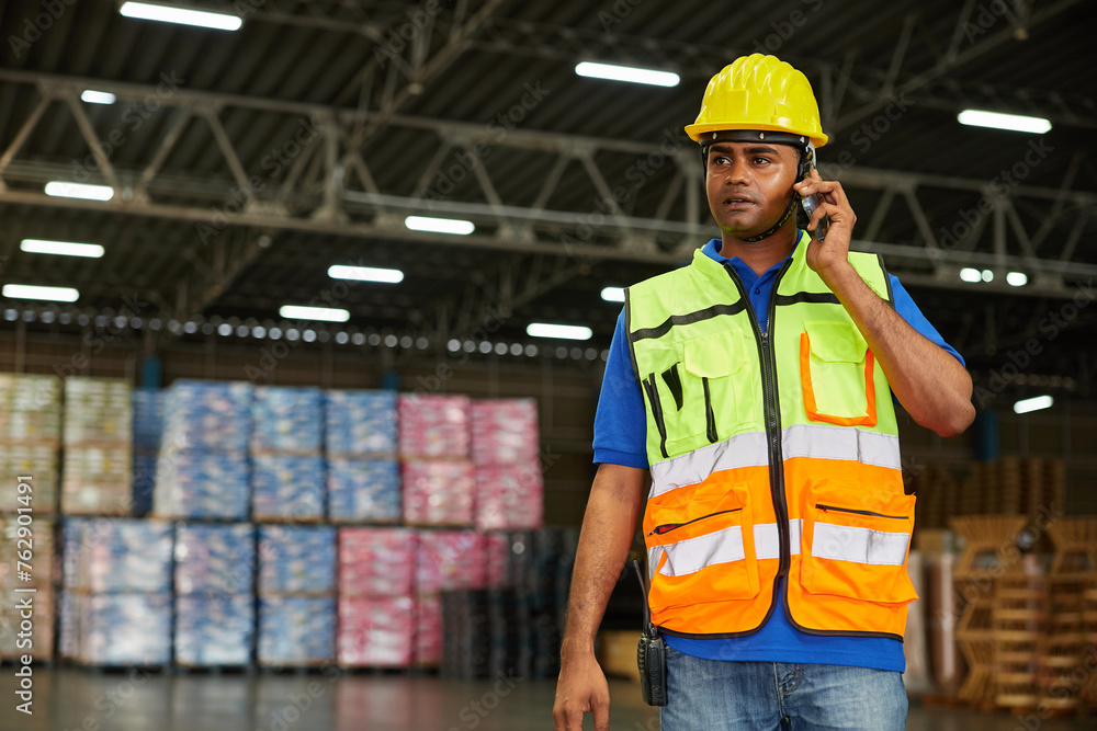 worker talking on smartphone to customer in the warehouse factory worker talking on smartphone to customer in the warehouse factory