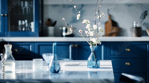 Empty and clean marble dining table in scandinavian kitchen Modern monochrome interior with blue drawers on wooden furniture Tablewear and vases with flowers : Generative AI