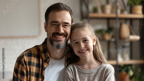 Happy handsome dad and cheerful tween kid girl looking at camera with toothy smiles, posing for home headshot portrait. Positive father piggibacking cute daughter head shot © ChomStyle