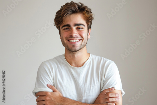 Portrait of handsome smiling young man with folded arms isolated white background.