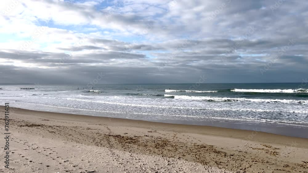 A beautiful clean sandy beach with waves in slow motion and dramatic clouds with the sun shining through. Caparica beach in Portugal A beautiful clean sandy beach with waves in slow motion and dramatic clouds with the sun shining through. Caparica beach in Portugal