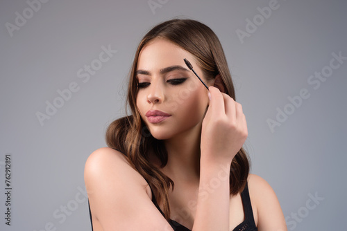 Eyebrow makeup. Beauty model shaping brows with brow pencil closeup. Womans eyebrows with eyebrow brush. Natural make up. Modeling brows. Comb eyebrows.