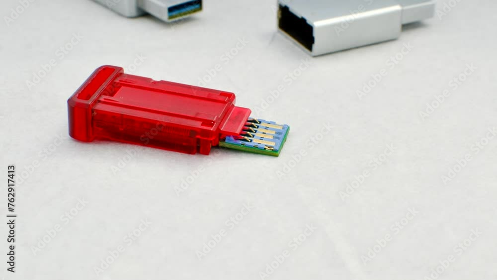 Close-up of a disassembled USB flash drive on a white background, revealing its internal complexity. Close-up of an open USB flash drive, exposing circuits and connections, on a white surface. Close-up of a disassembled USB flash drive on a white background, revealing its internal complexity. Close-up of an open USB flash drive, exposing circuits and connections, on a white surface.